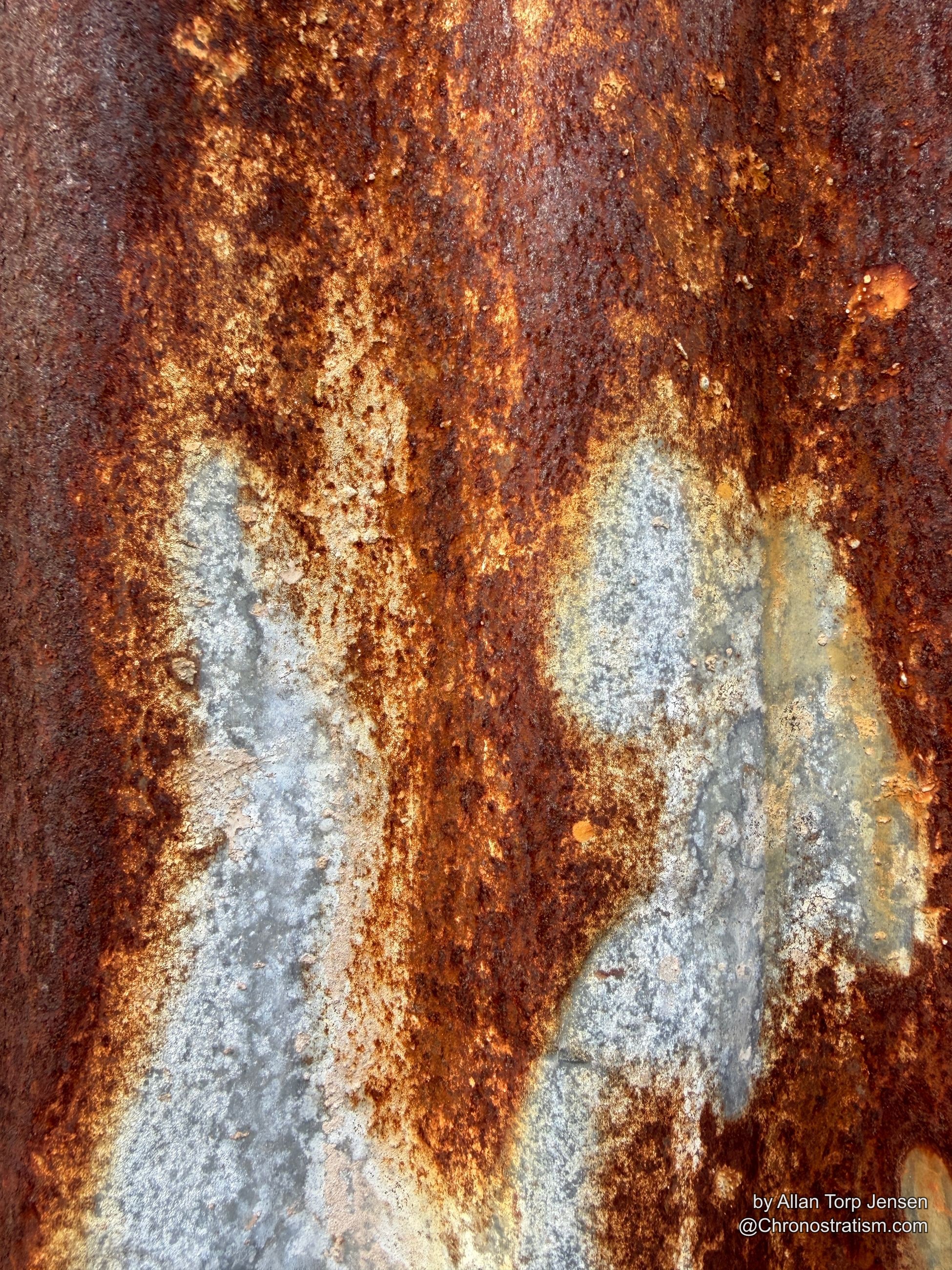 Deep rust saturates a corrugated panel in rich rust-brown and ochre tones.