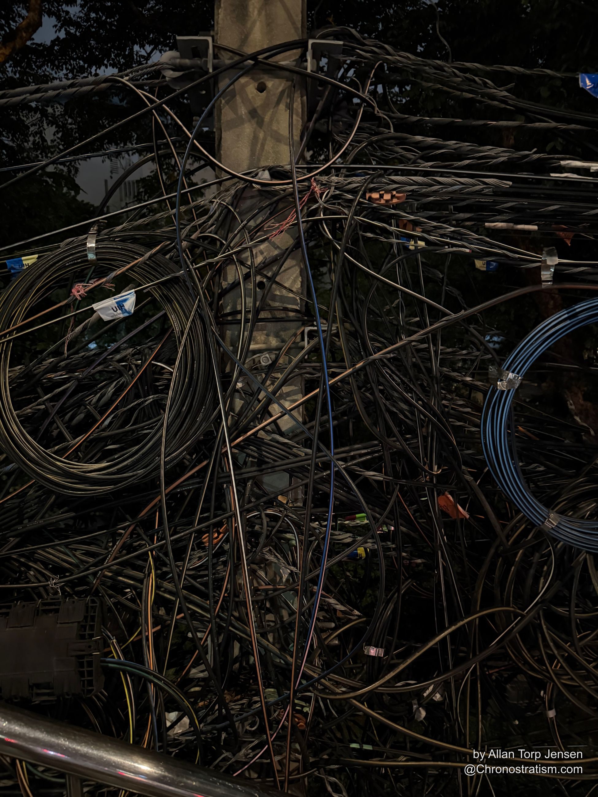 A dense tangle of black utility cables spills around a stencilled junction box marked SSD-SM.