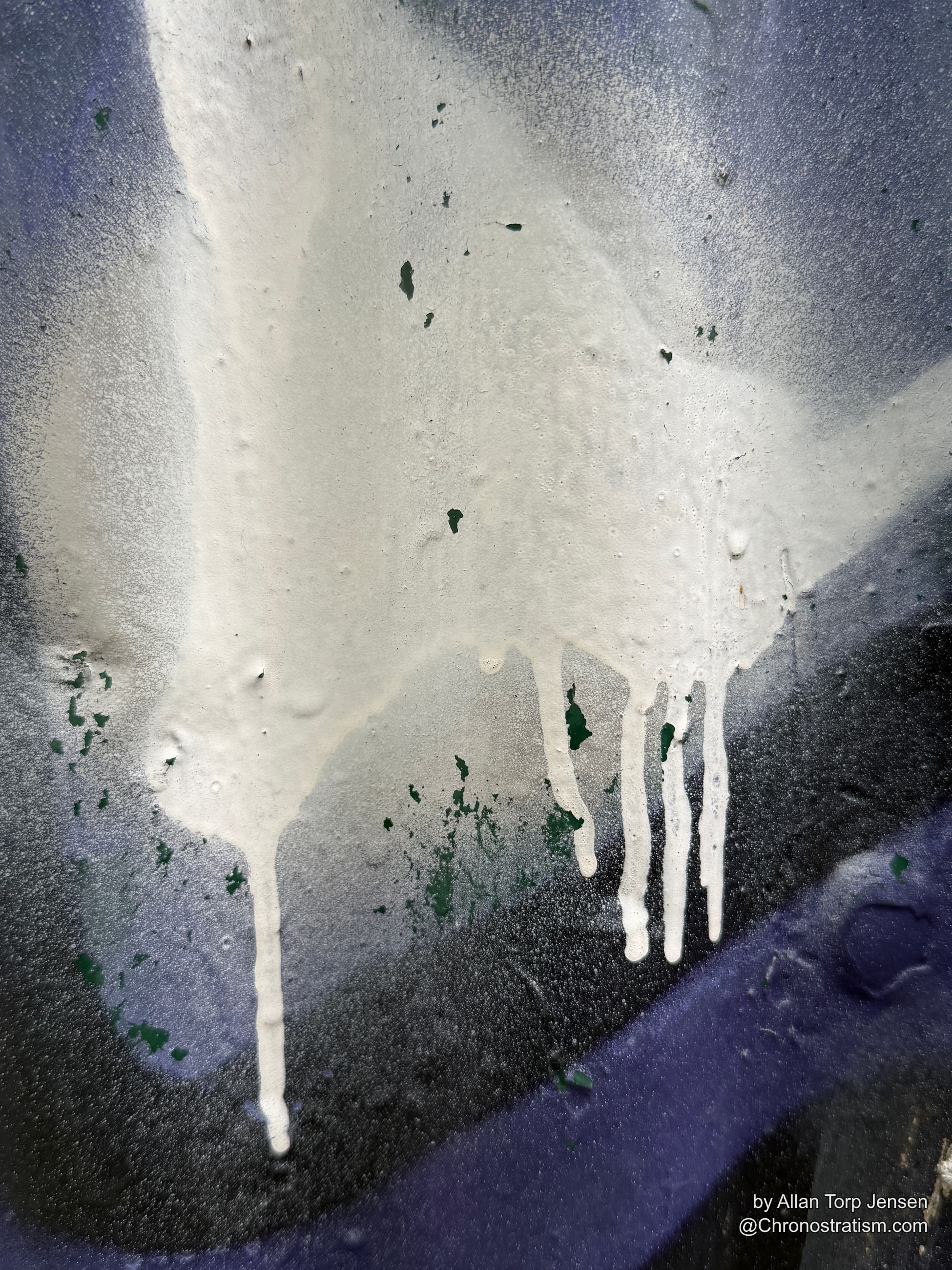 Drips of white paint pool over curling purple and green layers.
