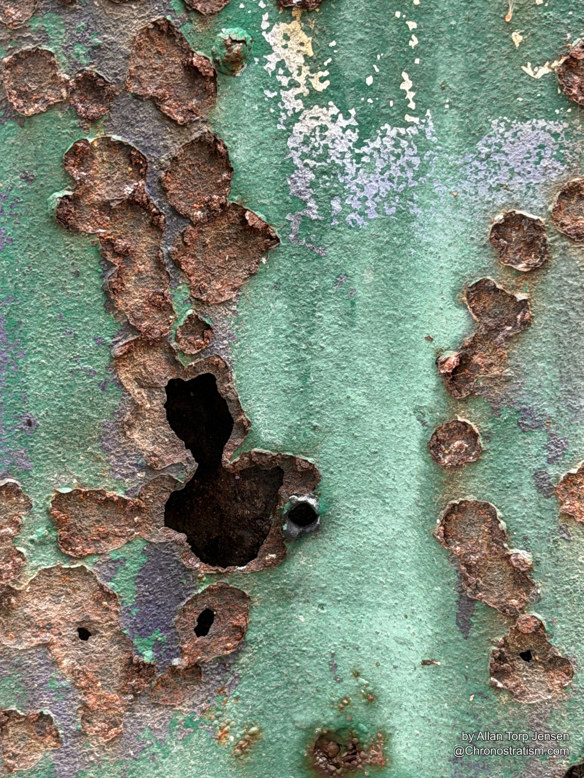 A final close view shows rust perforations spreading toward the panel's edge.