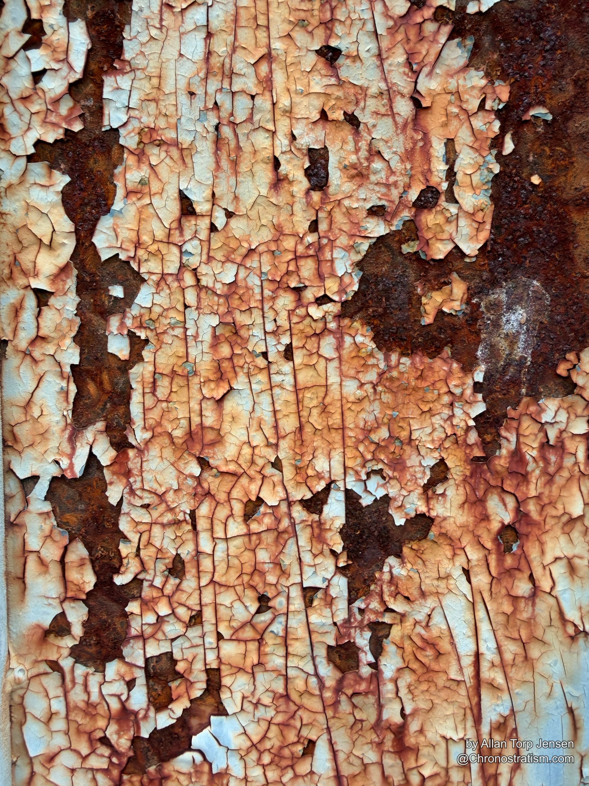 Heavy rust breaks through a craquelured white and rose-toned paint layer, dark corrosion pooling at the core.