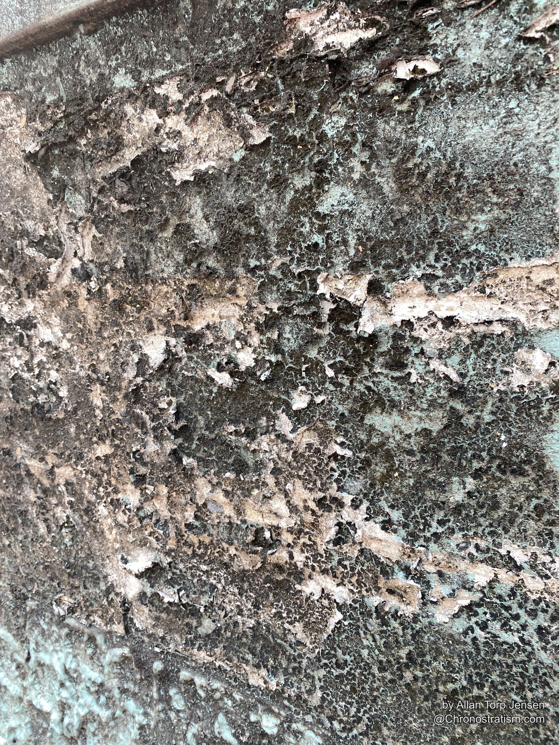 The mottled soot pattern continues, streaked where rain has run down the render.