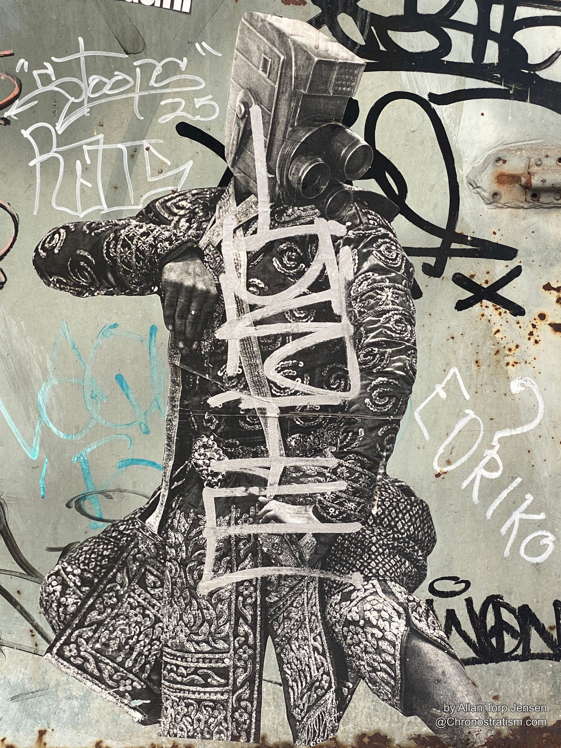 A paste-up collage of an ornate robed figure disappears beneath heavy black and blue tags.