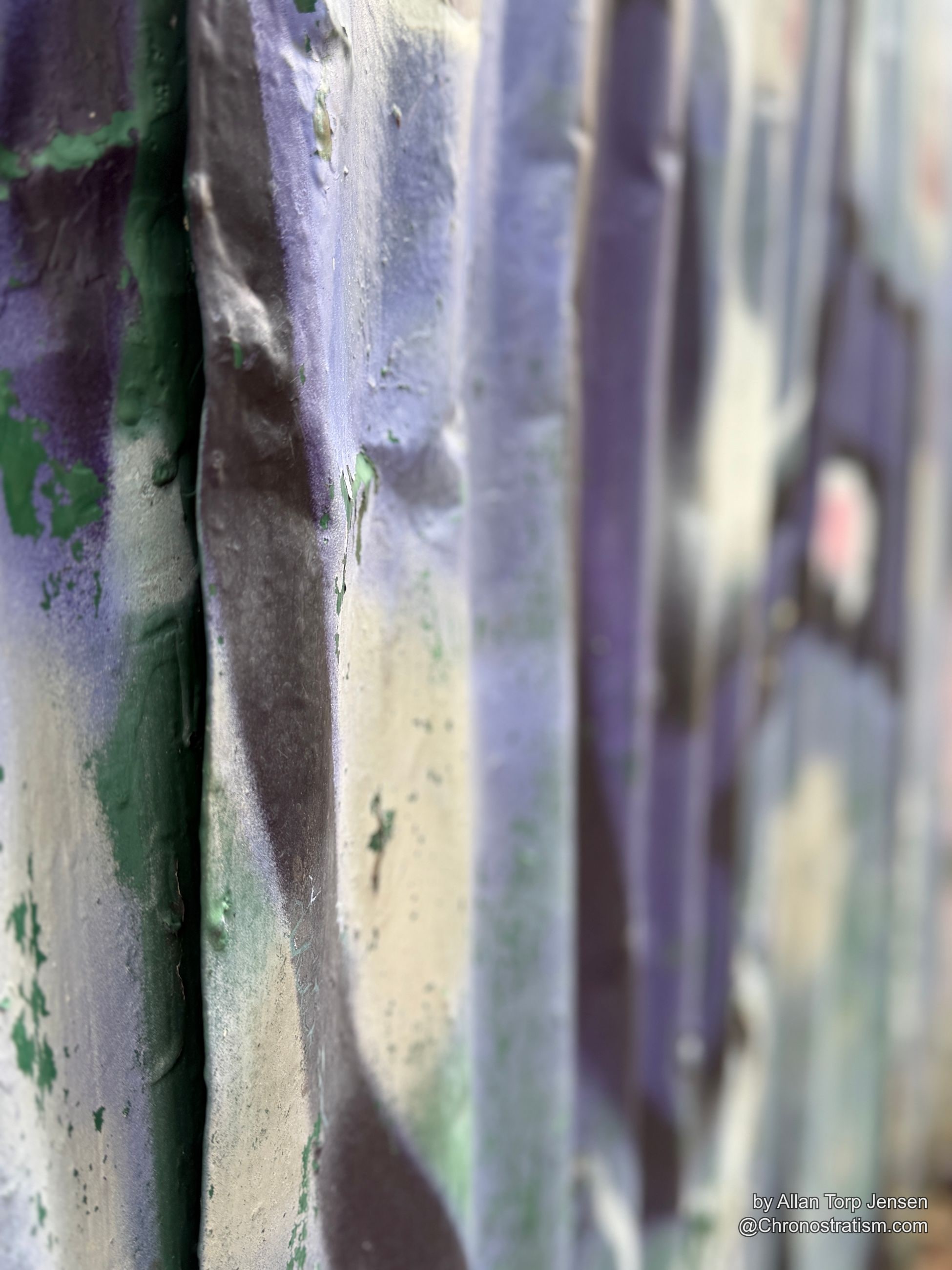 Rust perforates through the peeling paint in small clustered holes.