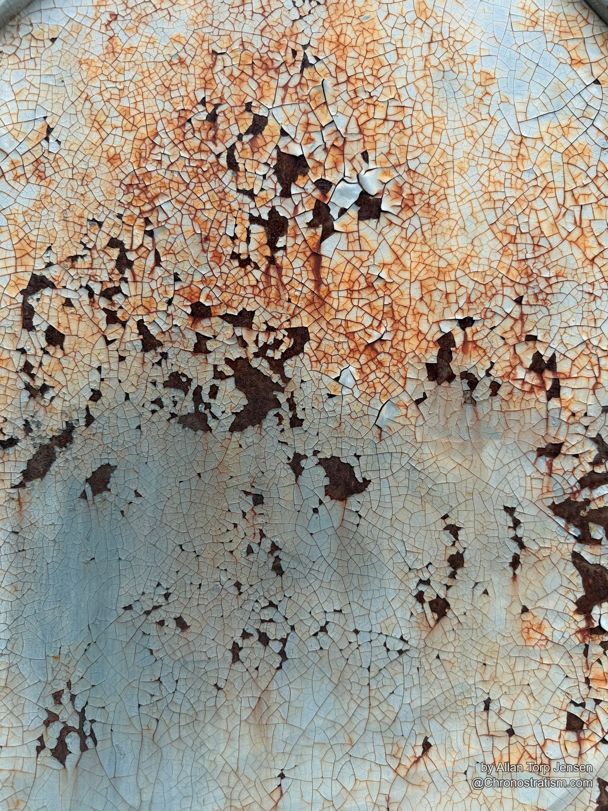 A sharp tonal divide splits rust-stained paint from clean cream craquelure across the same cracked surface.