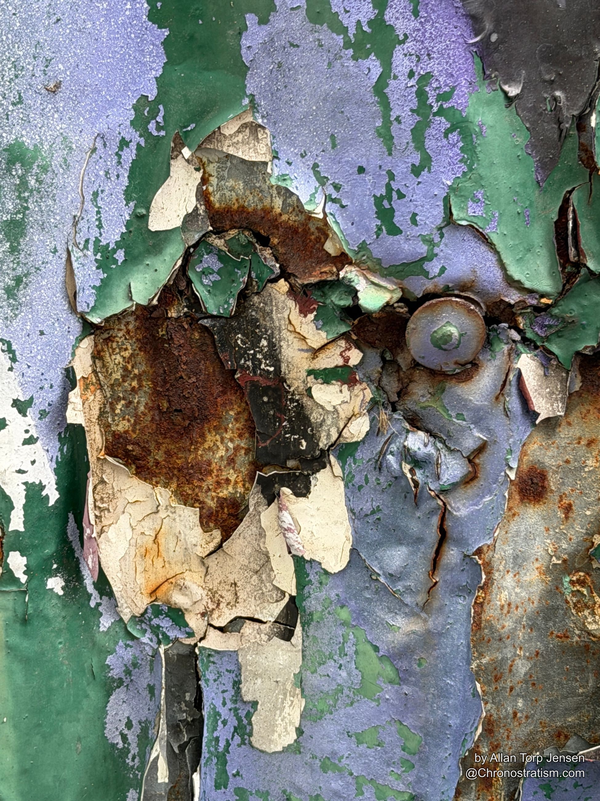 A structural crack runs through layered paint, rust bleeding from a rusted rivet.