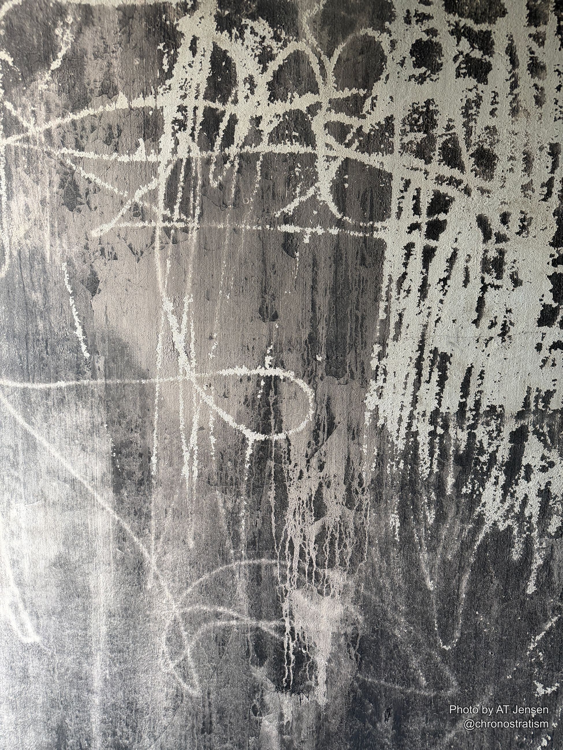 A white stencilled circle and numeral mark a soot-streaked wall.